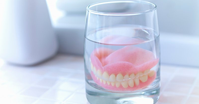 dentures in a cup of water per aftercare instructions 