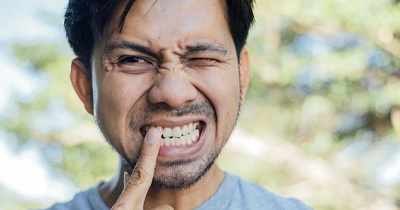 person pointing to their tooth