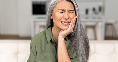 Woman with tooth pain needing emergency dentist in Grafton, ND