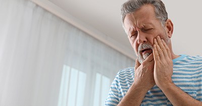 Man in striped shirt with tooth pain