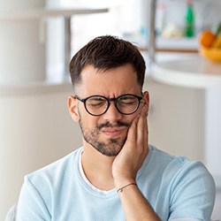 Close-up of man with glasses with tooth pain