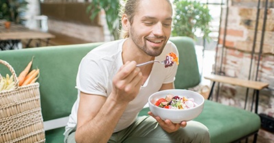 Patient in Grafton eating healthy food with dental implants