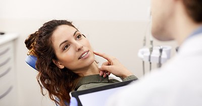 Woman talking to dentist during dental checkup