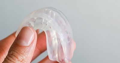 Patient holding clear mouthguard