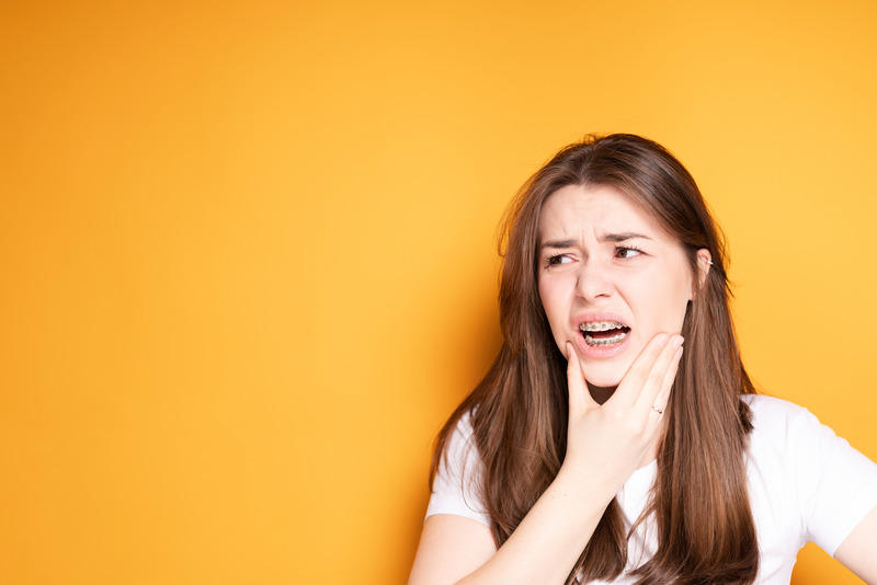 Patient holding their face due to dental emergencies